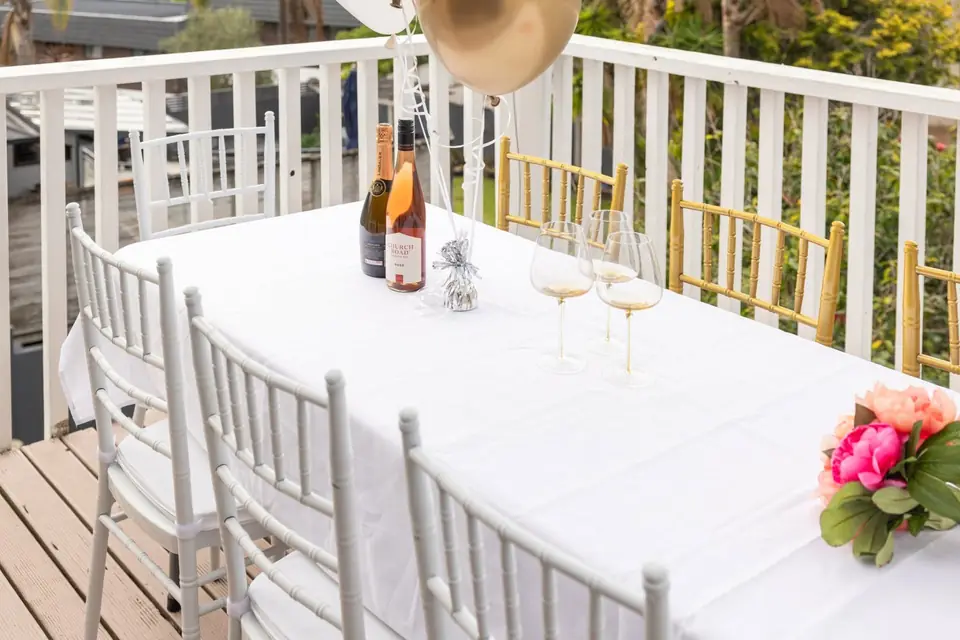 White Chiavari chairs around a trestle table set up for an Auckland event